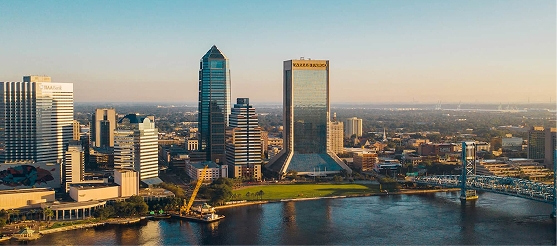 Aerial view of downtown Jacksonville, Florida skyline with St. Johns River and Main Street Bridge.