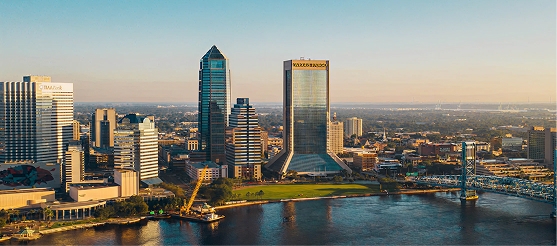 Downtown Jacksonville, Florida skyline at sunset with St. Johns River and Main Street Bridge in view.