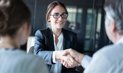 Smiling attorney shaking hands with client during legal consultation, representing trusted personal injury help.