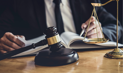 Lawyer reviewing legal documents at desk with gavel and justice scales, symbolizing personal injury law.